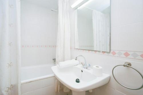 a white bathroom with a sink and a mirror at Rentalmar Decathlon in Salou