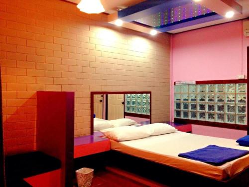 a room with two beds and a mirror in it at Zigzag Resort in Ban Som Poi