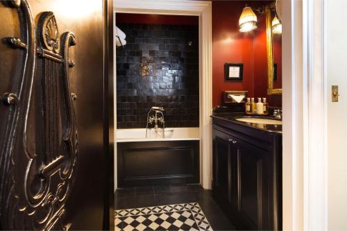 a black bathroom with a shower and a sink at Villa d'Estrées in Paris
