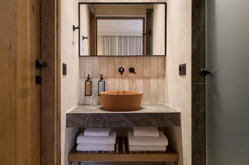 a bathroom with a sink and a mirror and towels at Stella Village Seaside Hotel in Hersonissos
