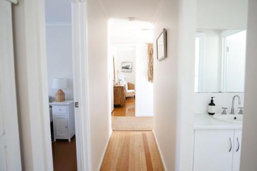 a white kitchen with a sink and a mirror at 'The Perch' - Central location in Robe, park your car and walk to everything in Robe