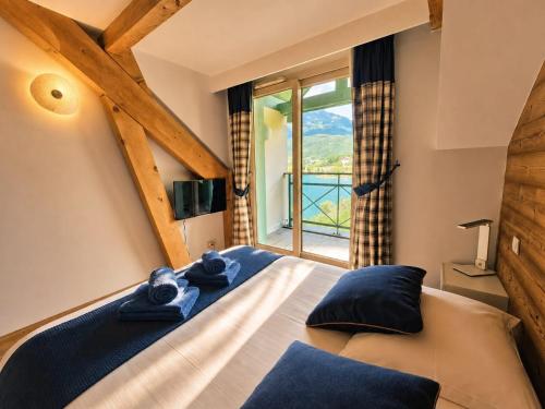 a bedroom with a bed with a large window at Appartement 202 Geroli Lac d'Annecy in Duingt