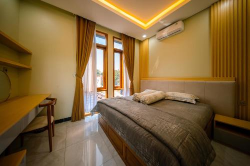 a bedroom with a bed and a large window at Bhumi Nawasena in Semalen