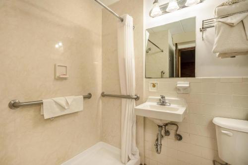 a bathroom with a sink and a toilet and a mirror at Econo Lodge Inn & Suites Windsor Locks Bradley Airport in Windsor Locks