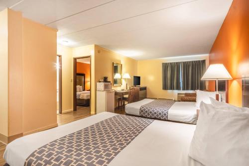 a hotel room with two beds and a desk at Econo Lodge Inn & Suites Windsor Locks Bradley Airport in Windsor Locks
