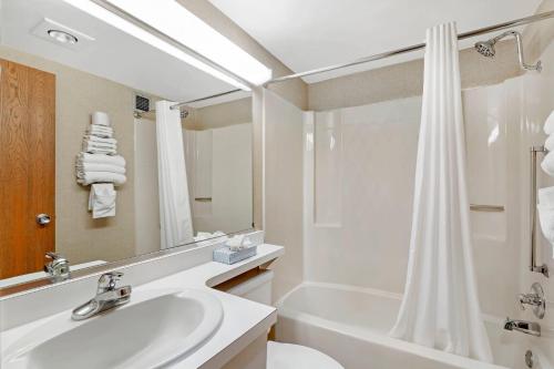 a bathroom with a sink and a tub and a shower at Rodeway Inn Columbia Mall Loop in Grand Forks