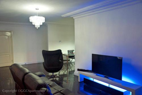 a living room with a couch and a flat screen tv at GGC Luxury Serviced Apartment - Platinum in Lagos