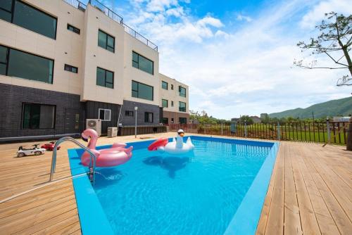a swimming pool with inflatables in front of a building at Namiseom 2020 Spa Poolvilla in Chuncheon