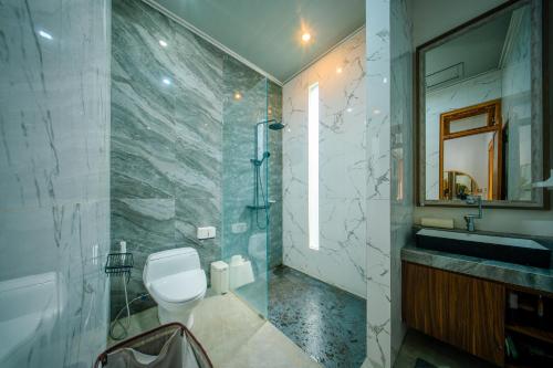 a bathroom with a toilet and a sink and a mirror at Bhumi Nawasena in Semalen