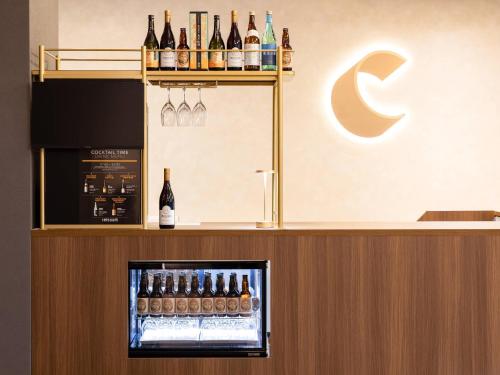 a bar with bottles of wine on a counter at Comfort Hotel ERA Tokyo Higashi Kanda in Tokyo