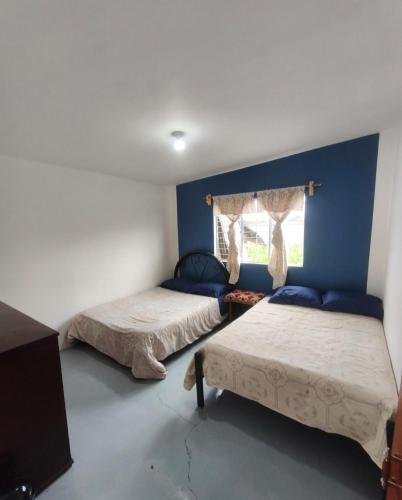 a bedroom with two beds and a window at Alojamiento Casa Chuy in Jicolapa