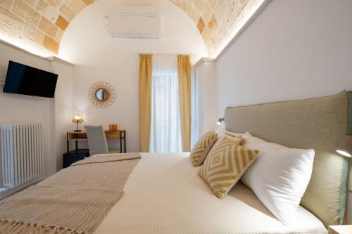 a bedroom with a large white bed with pillows at Celine Dimora e Suite in Copertino