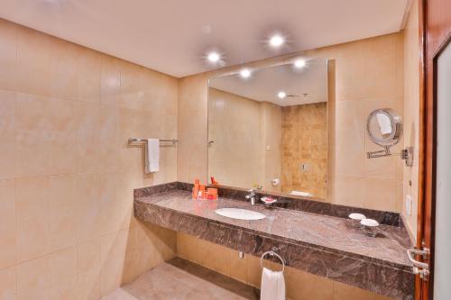 a bathroom with a sink and a large mirror at Avari Boutique Multan in Multan
