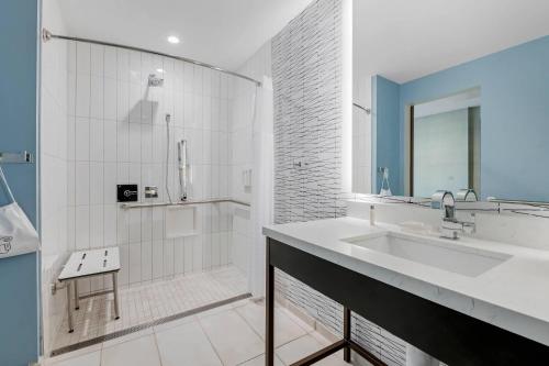a white bathroom with a sink and a shower at Cambria Hotel Austin Downtown in Austin
