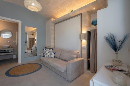 a living room with a couch and a mirror at Dimora Sofia, Charming House in Savelletri di Fasano