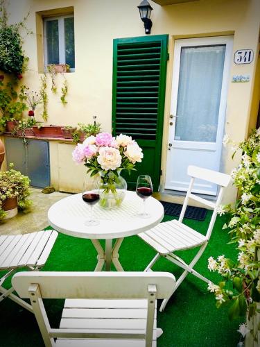 a table with a vase of flowers and two chairs at Suite La Corte in Florence