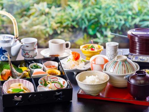 a table with a tray of food and cups and dishes at Izukogen Hotel Itsutsuboshi in Ito