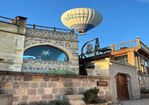 a hot air balloon flying over a building at Wings Cappadocia in Uçhisar