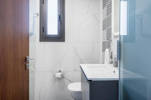 a bathroom with a toilet and a sink and a mirror at Mayan 2-Bedroom Apartment in Larnaca