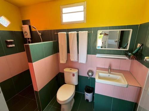 a colorful bathroom with a toilet and a sink at ฮิมฝาย โฮมสเตย์ บึงกาฬ in Ban Nong Khang Kha