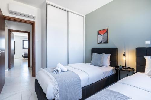 a bedroom with two beds and a hallway at Mayan 2-Bedroom Apartment in Larnaca