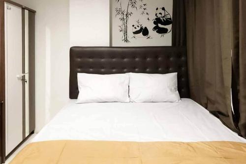 a bed with a black headboard and white pillows at SAS Guest House Mitra RedDoorz At Darmo Park 2 Surabaya in Surabaya