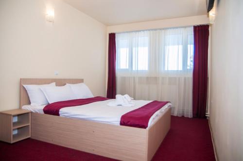 um quarto de hotel com uma cama e uma janela em Dumbrava Minunata em Braşov