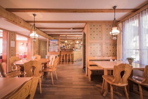 ein Restaurant mit Holztischen und -stühlen und einer Bar in der Unterkunft Gasthof Schoenegg B&B in Goldswil