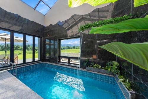 a swimming pool in a house with a large window at Goseung Poolhouse Poolvilla 151 in Goseong