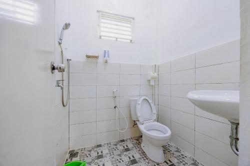 a bathroom with a toilet and a sink at RedDoorz at Batutulis Bogor Villa Papatong by M in Bogor