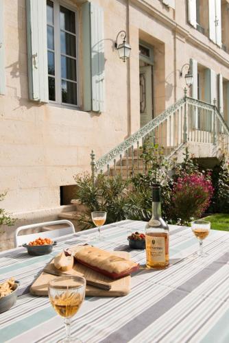 a table with a bottle of wine and some bread at La Tillaie SPA et Sauna in Pont-lʼAbbé-dʼArnoult