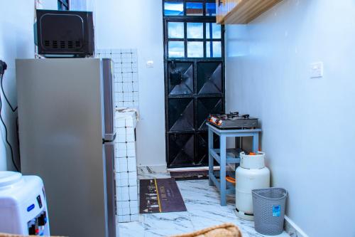 a kitchen with a refrigerator and a tv on top at JULIAH NASERIAN BnBS in Narok