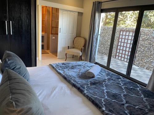 a bedroom with a bed and a chair and a window at Reef View BnB in East London