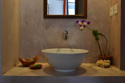 a bathroom with a bowl sink with a flower in it at The Secret Guesthouse in Mirissa