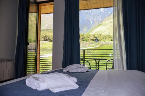 a bedroom with a bed and a view of a mountain at Kazbegi Hotel Grand View in Kazbegi