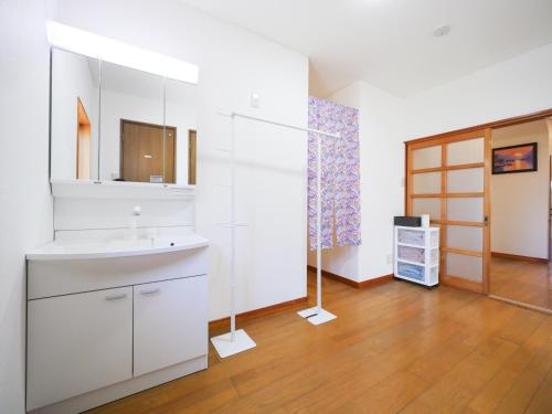 a white bathroom with a sink and a mirror at 雪の宿 in Numata