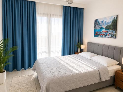 a bedroom with blue curtains and a large bed at Rıversıdelıfe Iskele M 147 in Aglantzia