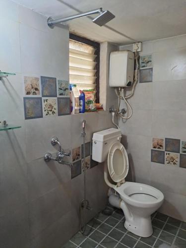 a bathroom with a toilet and a shower stall at Siddhi Home Stay in Kolhapur