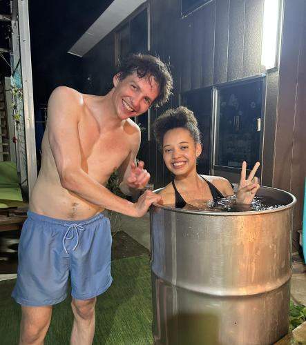 a man and a boy standing in a hot tub at ログハウス1棟貸し,持込み自由,サウナ,露天風呂にバーべキュウや薪割り,ソーメン流しに収穫体験が楽しめます in Kashima