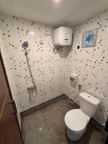 a bathroom with a toilet and a shower at Contana Paris in Girijati