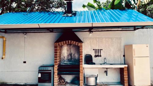 a small house with a blue roof and a kitchen at Casa Largo Katayama in Ruiosucio