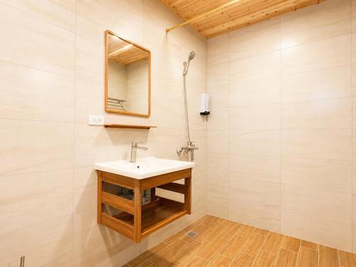 a bathroom with a sink and a mirror at Songfeng B&B in Luye