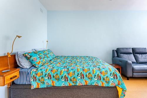 a bedroom with a bed and a blue chair at Captain's Pick at Manly Beach plus Parking in Sydney