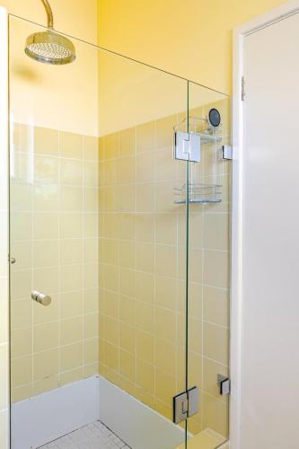 a bathroom with a shower with a glass door at Captain's Pick at Manly Beach plus Parking in Sydney