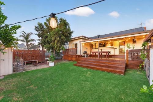 a backyard with a wooden deck and green grass at Styled Entertainer only mins from CBD in Bendigo