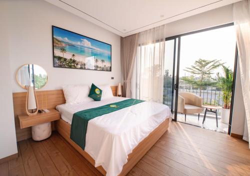 a bedroom with a large bed and a balcony at Villa The Pearl -Vlasta Sầm Sơn in Sầm Sơn
