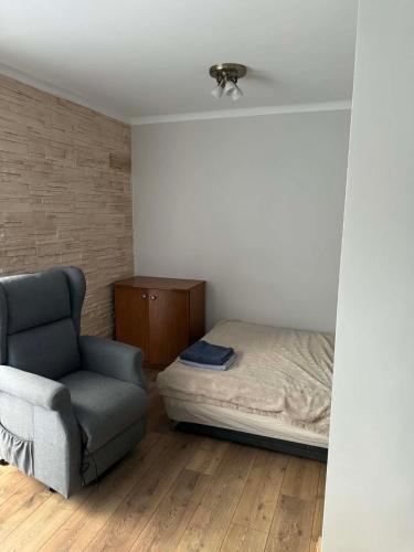 a bedroom with a bed and a chair at Wygodny kąt in Tarnobrzeg