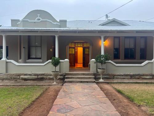 a white house with a orange door and stairs at River and Ridge in Cradock