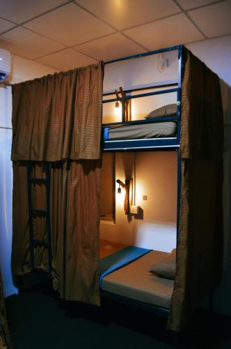 two bunk beds in a room with a window at Waves & Paws Hostel in Arugam Bay