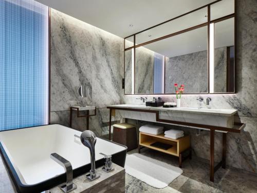 a bathroom with a tub and a sink at InterContinental Zhuhai by IHG in Zhuhai